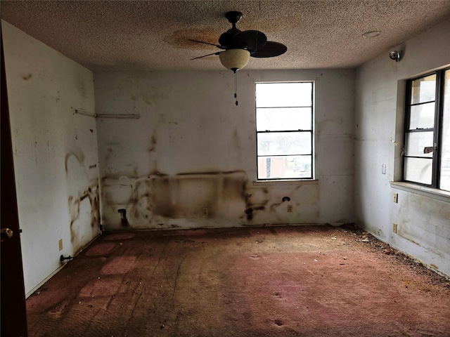 misc room featuring ceiling fan and a textured ceiling