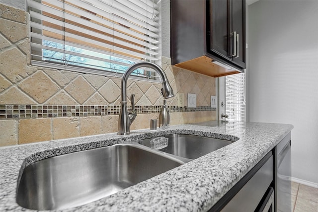 details with light stone counters, sink, and backsplash