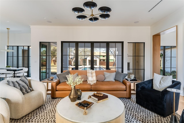 living room with crown molding and a chandelier