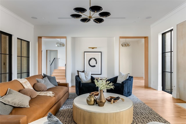 living room with crown molding, light hardwood / wood-style flooring, and a notable chandelier