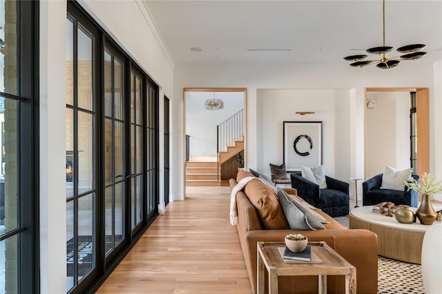 living room with ornamental molding and light hardwood / wood-style flooring