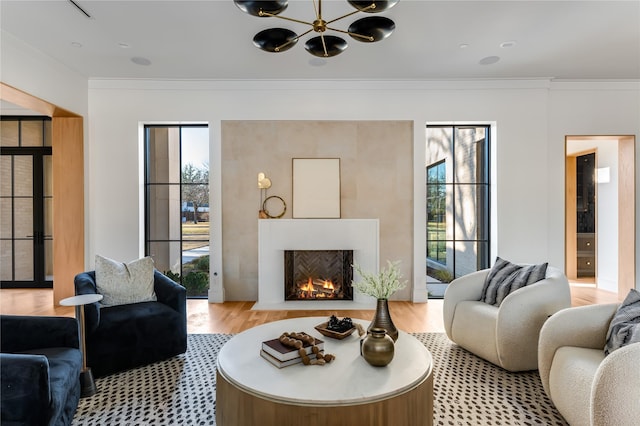 living room featuring ornamental molding, light hardwood / wood-style floors, and a wealth of natural light