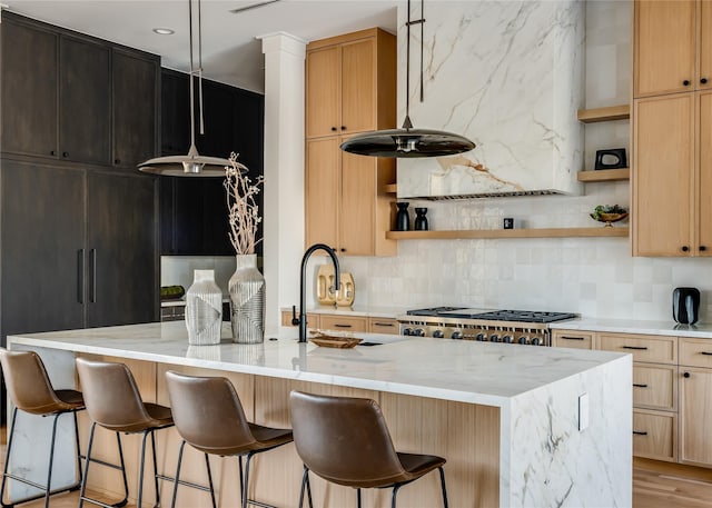 kitchen with light stone countertops, backsplash, and decorative light fixtures