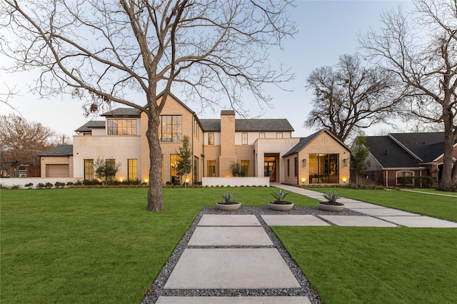 view of front of house with a garage and a front lawn