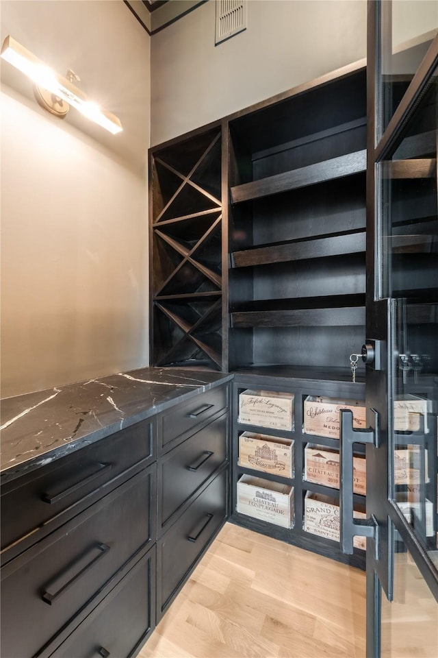 wine cellar with light hardwood / wood-style flooring