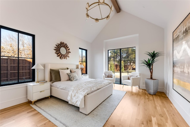 bedroom with beam ceiling, high vaulted ceiling, access to outside, and light hardwood / wood-style floors