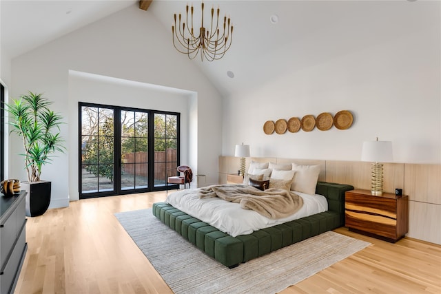 bedroom featuring access to exterior, beam ceiling, light hardwood / wood-style floors, and high vaulted ceiling