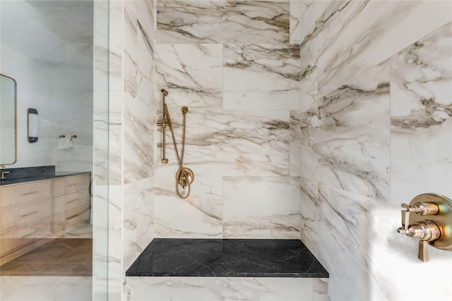 bathroom with vanity and a tile shower