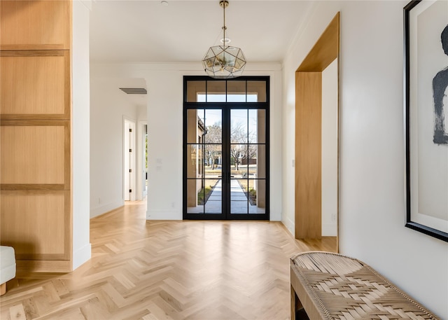 doorway to outside featuring light parquet floors, crown molding, a notable chandelier, and french doors