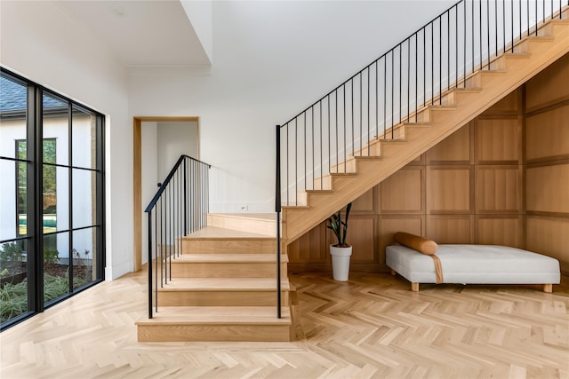 stairway featuring parquet flooring