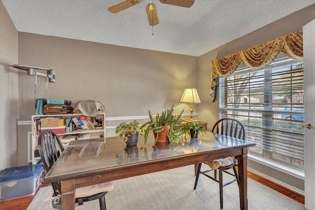 dining room with hardwood / wood-style flooring, ceiling fan, and a textured ceiling