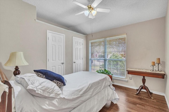 bedroom featuring ceiling fan, hardwood / wood-style floors, and a textured ceiling