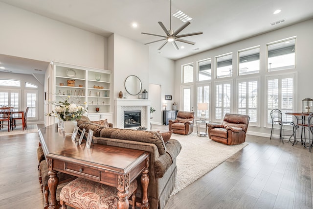 living room featuring a high ceiling, hardwood / wood-style floors, and ceiling fan