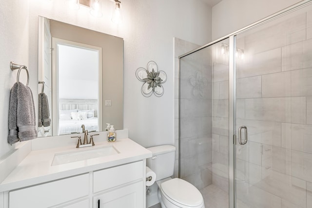 bathroom featuring vanity, toilet, and a shower with shower door