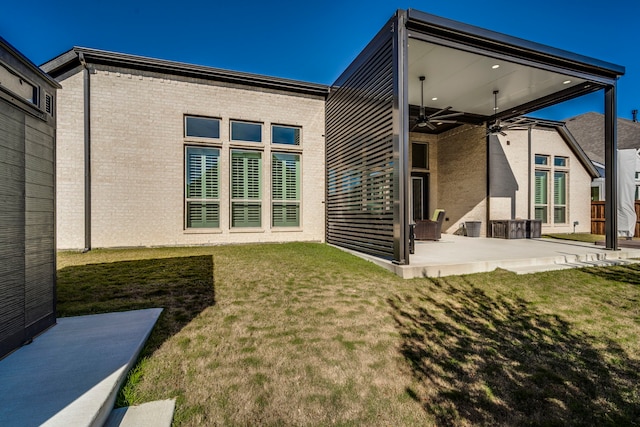 rear view of house featuring a patio area, ceiling fan, and a lawn