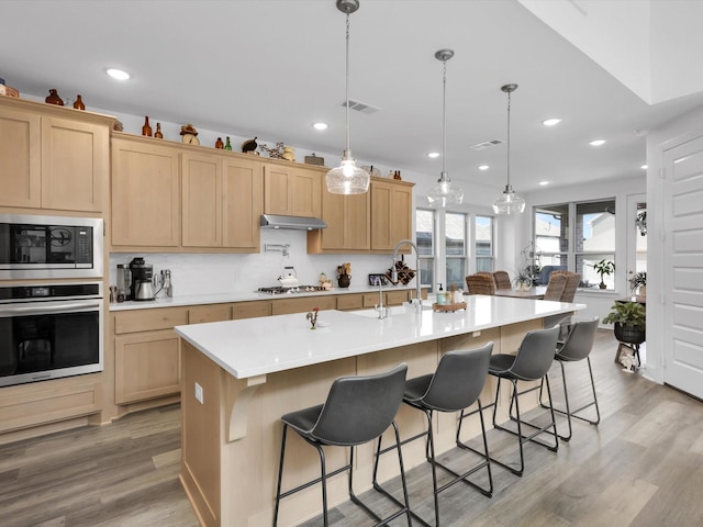 kitchen featuring visible vents, light wood-style flooring, stainless steel appliances, and light countertops