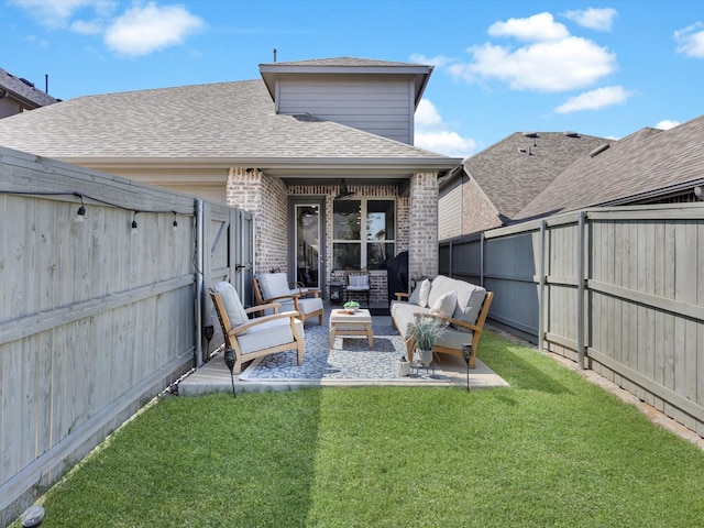 rear view of house with a fenced backyard, a shingled roof, a lawn, brick siding, and an outdoor hangout area