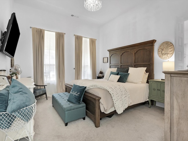 carpeted bedroom featuring an inviting chandelier