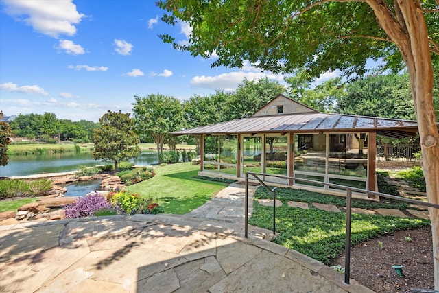 view of property's community featuring a lawn and a water view