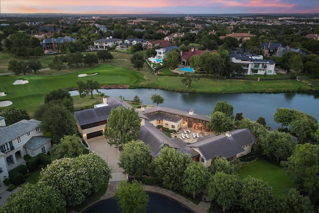 aerial view at dusk featuring a water view