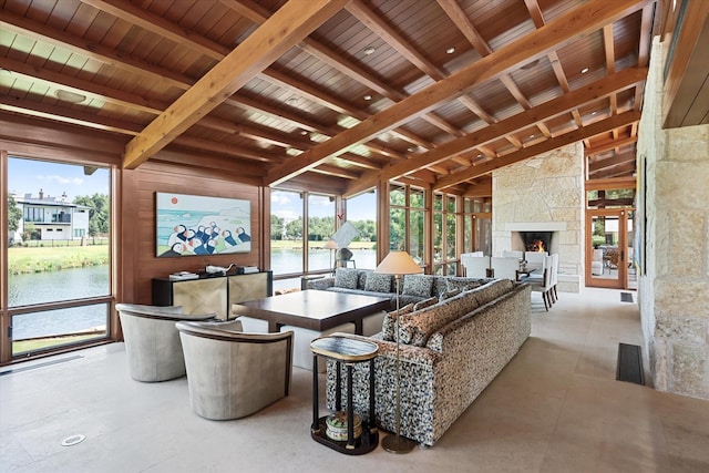 living room with a water view, wood ceiling, a fireplace, and beamed ceiling