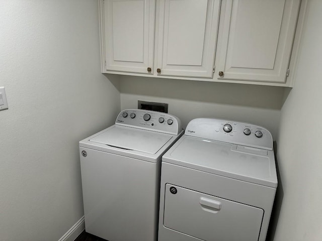 laundry room with washing machine and dryer and cabinets