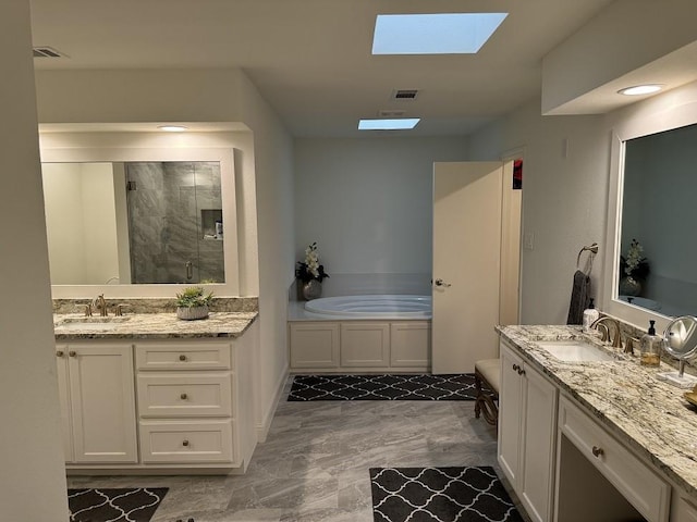 bathroom featuring vanity, a skylight, and shower with separate bathtub