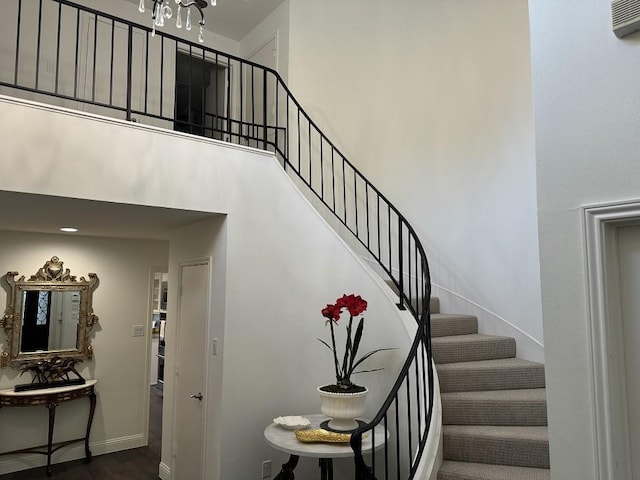 stairway featuring hardwood / wood-style floors and a towering ceiling