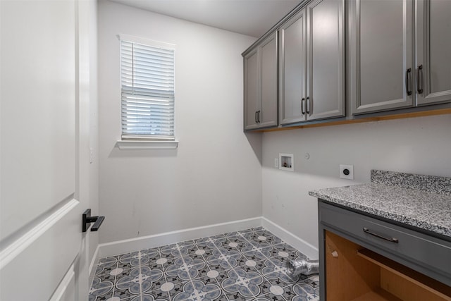 laundry room with electric dryer hookup, hookup for a washing machine, and cabinets