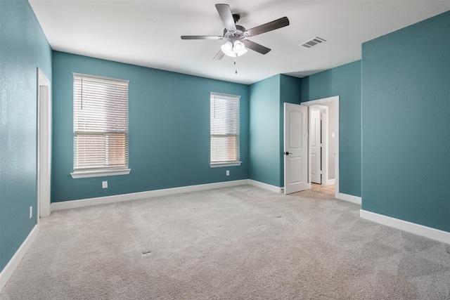 carpeted spare room featuring ceiling fan