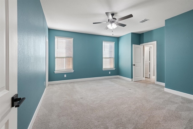 empty room featuring ceiling fan and light carpet