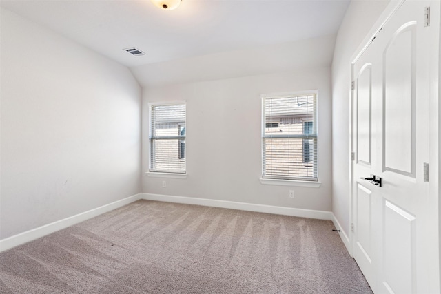 unfurnished room featuring lofted ceiling, carpet floors, and a wealth of natural light