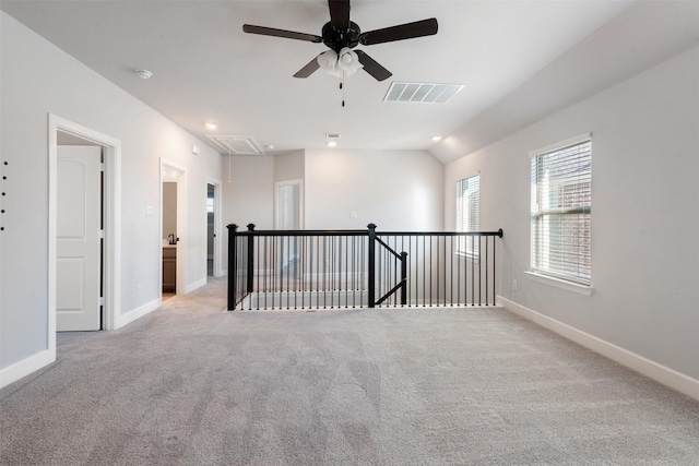 empty room with light colored carpet and lofted ceiling