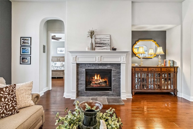 living room with hardwood / wood-style floors and a stone fireplace