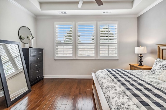 bedroom with dark hardwood / wood-style flooring, a raised ceiling, and multiple windows