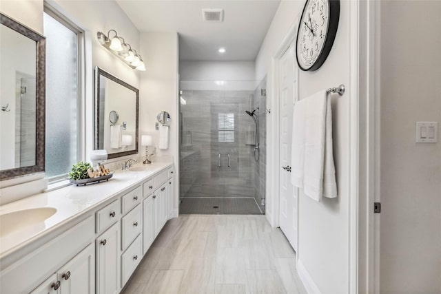 bathroom with a shower with shower door and vanity