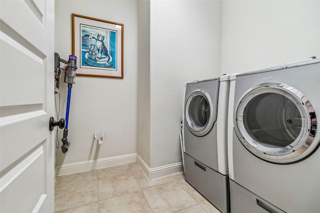 laundry room featuring washing machine and clothes dryer and light tile patterned floors