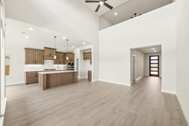 3350 Blazing Star Dr, Crandall, TX 75114 - kitchen featuring appliances with stainless steel finishes, ceiling fan, brown cabinetry, open floor plan, and recessed lighting