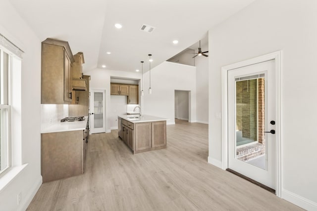 3350 Blazing Star Dr, Crandall, TX 75114 - kitchen featuring brown cabinetry, a sink, stainless steel gas stovetop, open floor plan, and ceiling fan