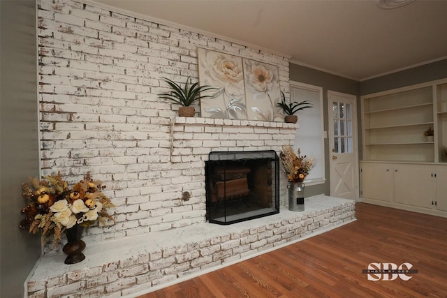 unfurnished living room featuring ornamental molding, a fireplace, and hardwood / wood-style floors