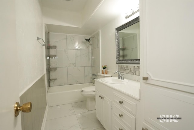 full bathroom featuring tiled shower / bath, vanity, and toilet