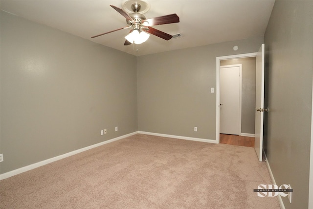 empty room featuring ceiling fan and light colored carpet