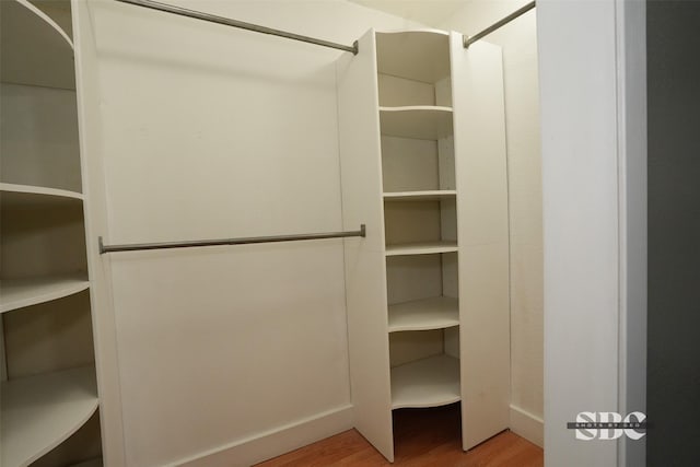 walk in closet with light hardwood / wood-style flooring