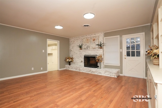 unfurnished living room with crown molding, a fireplace, and light wood-type flooring