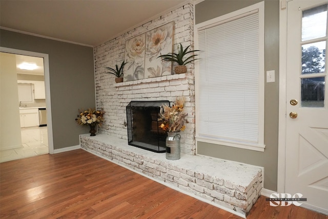 unfurnished living room with hardwood / wood-style flooring, a fireplace, and crown molding