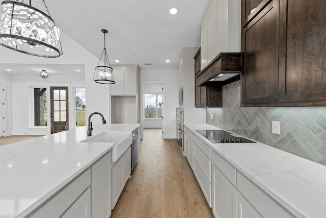 kitchen featuring light stone counters, hanging light fixtures, and appliances with stainless steel finishes