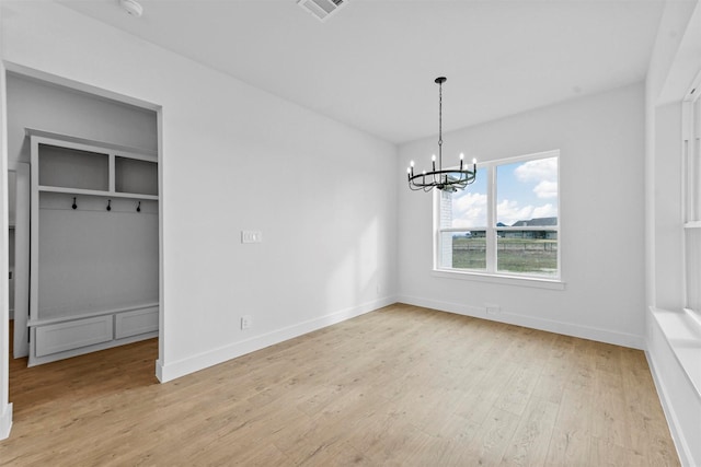 unfurnished dining area with light hardwood / wood-style flooring and a chandelier