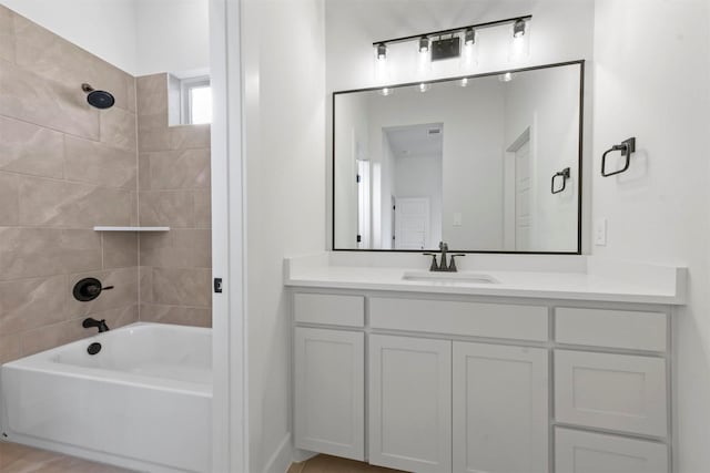 bathroom with tiled shower / bath combo and vanity