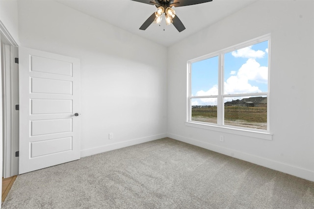 carpeted spare room featuring ceiling fan