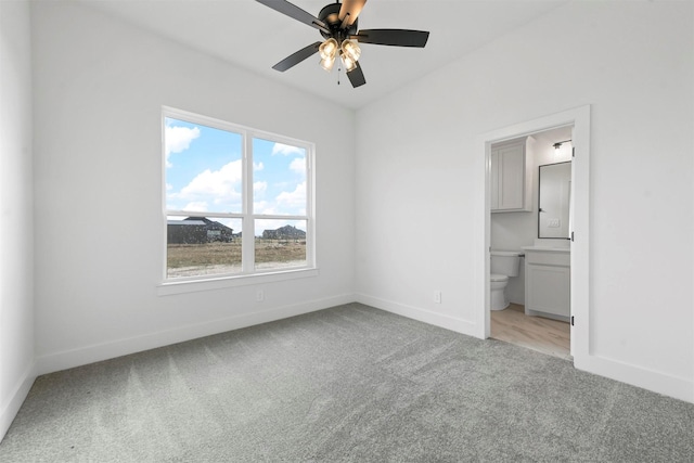 unfurnished bedroom featuring connected bathroom, light colored carpet, and ceiling fan